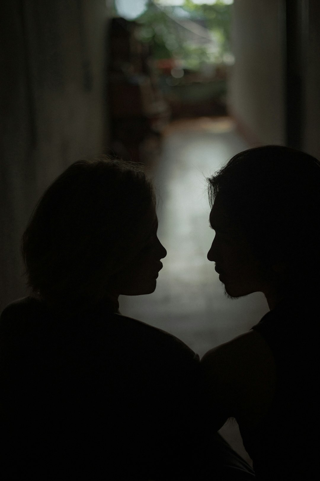two people whispering in shadow